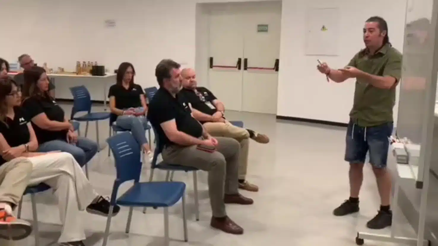 Presentación técnica: César Rojas explicando con entusiasmo ante un equipo de empresa